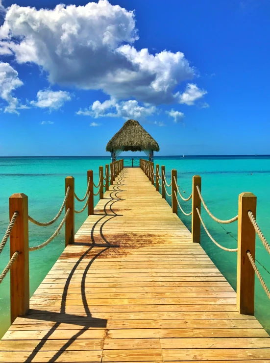 a pier leads out to the ocean on a sunny day