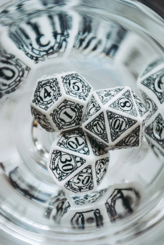 a group of dice sit inside a crystal bowl