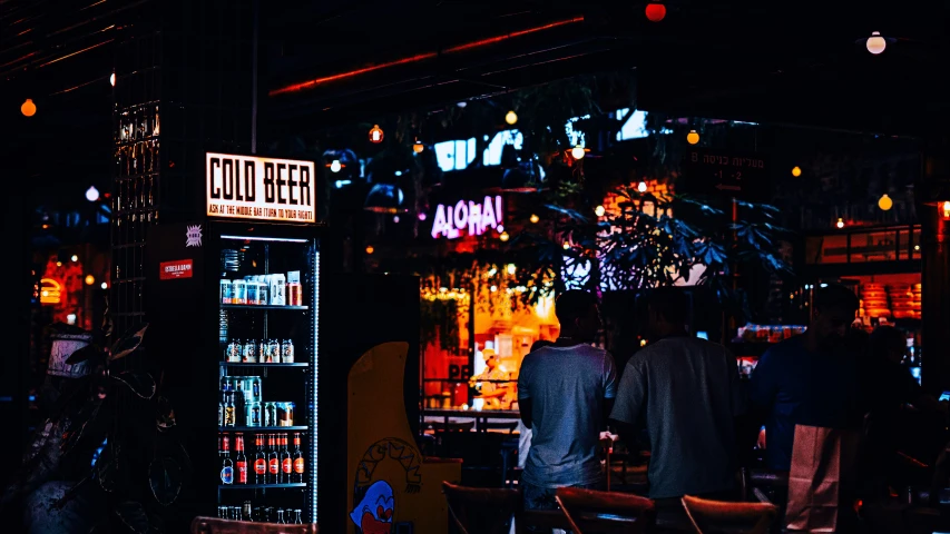 people at night walking through an illuminated storefront