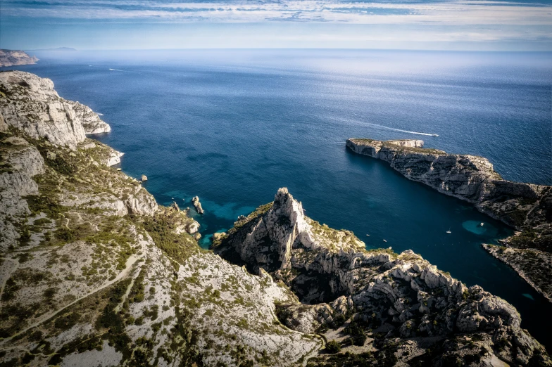 an aerial view of two rocky cliff and a body of water