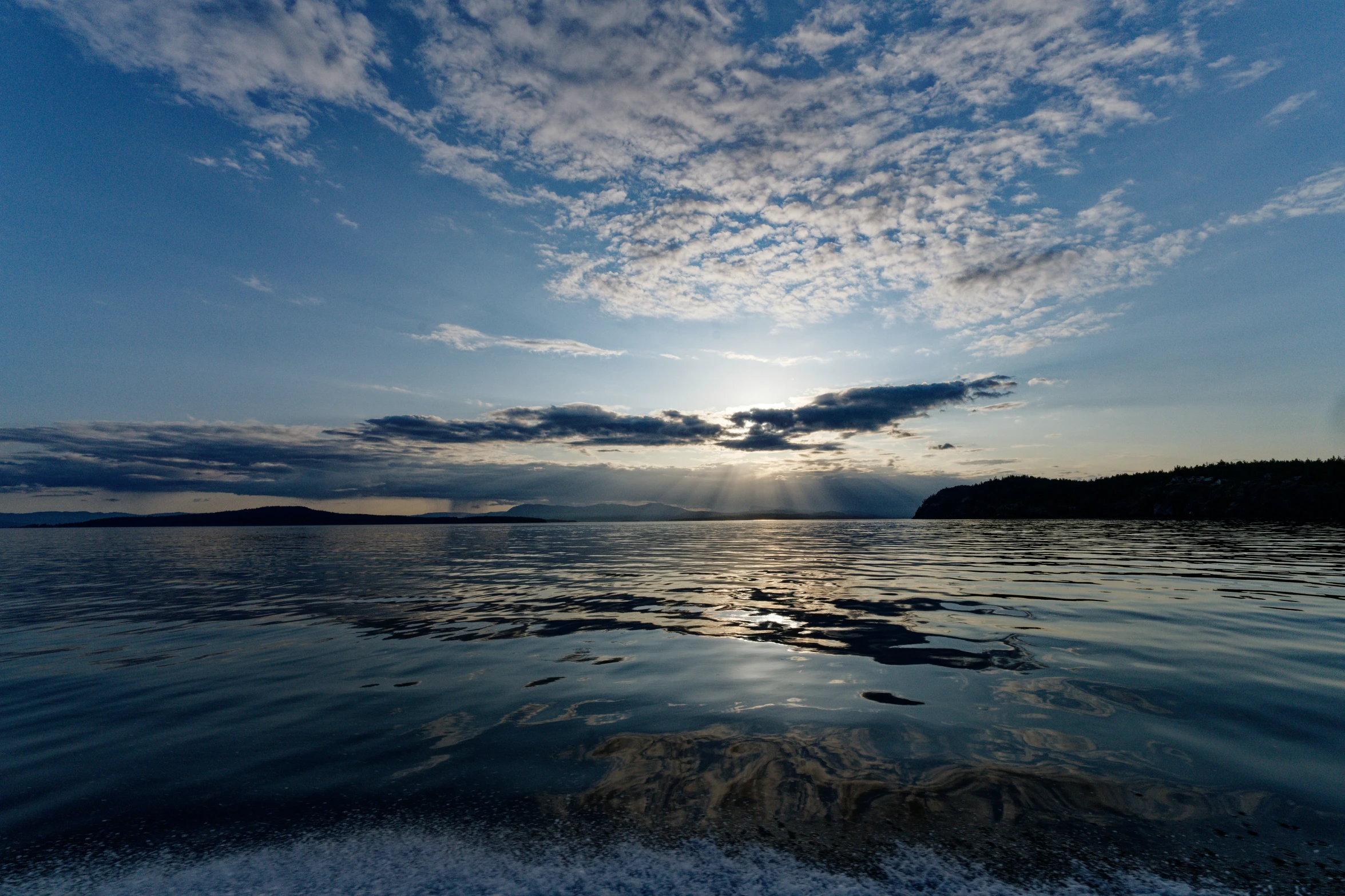 a beautiful sunset with clouds moving over the lake