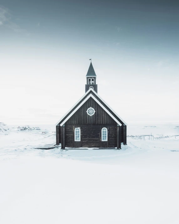 a small church with a steeple sitting in the middle of nowhere