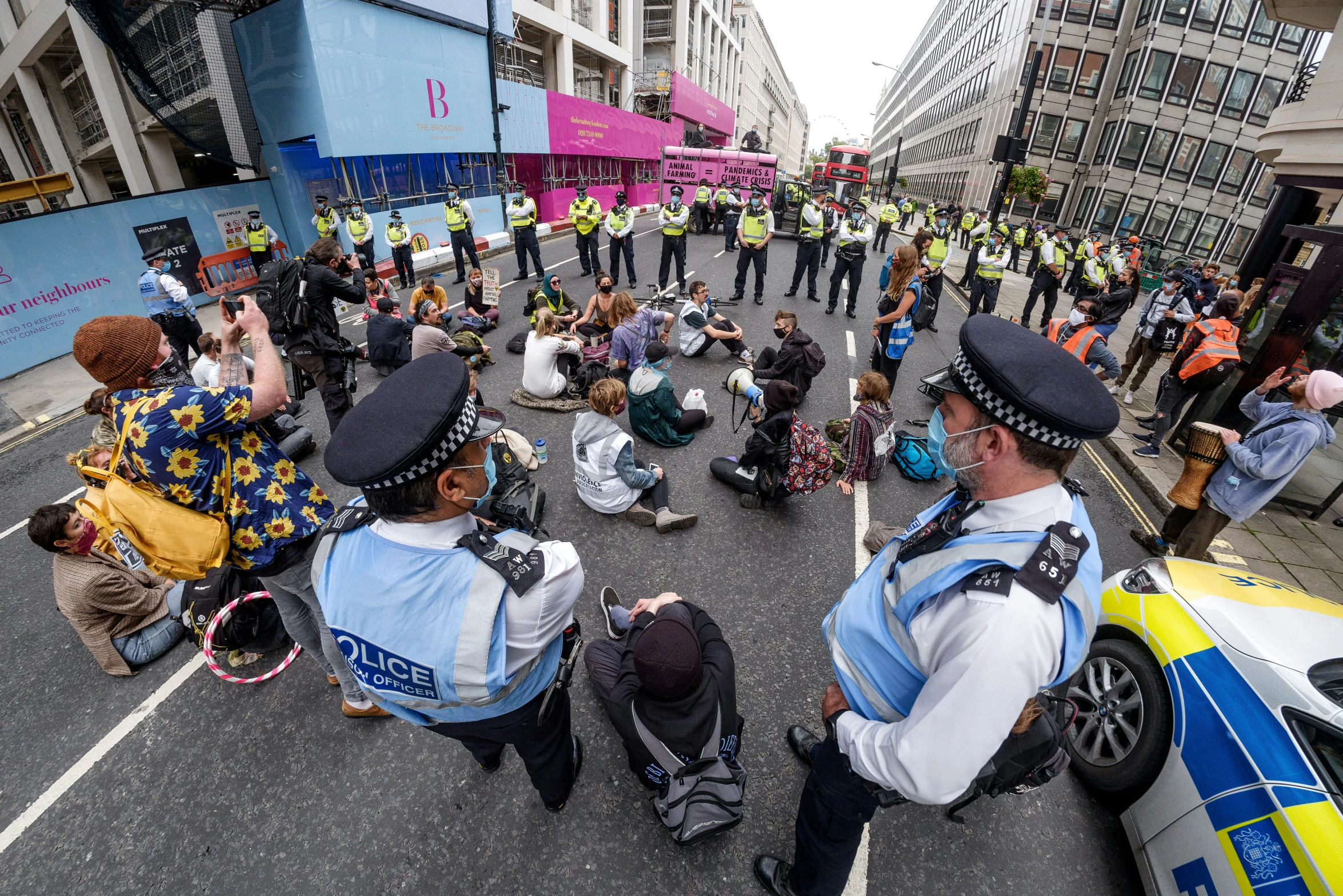 a group of people standing in the street next to a policeman