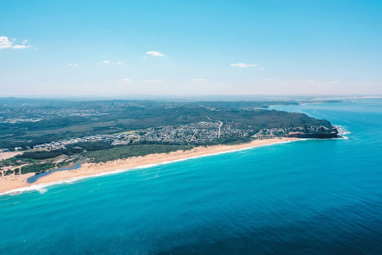 a beach with clear blue water and buildings