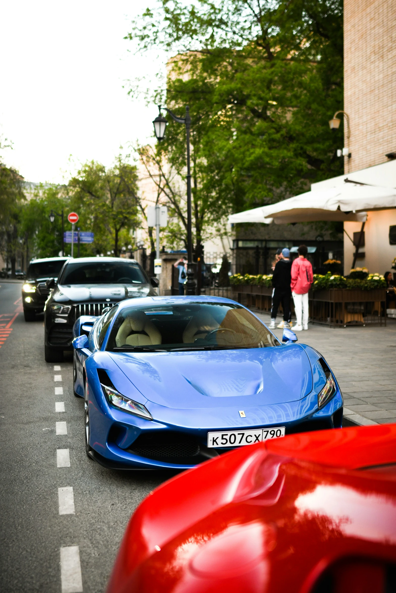 several different cars lined up on the side of a road