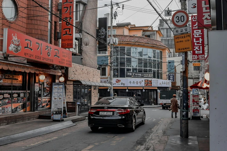 a car sitting on the side of the street near some buildings