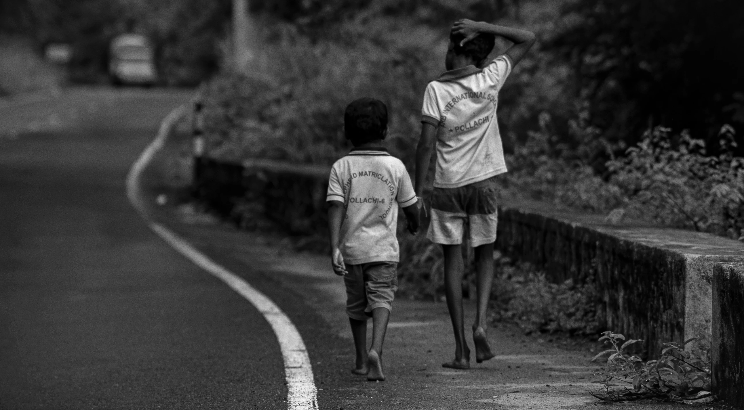 two people walking down a road in the dark