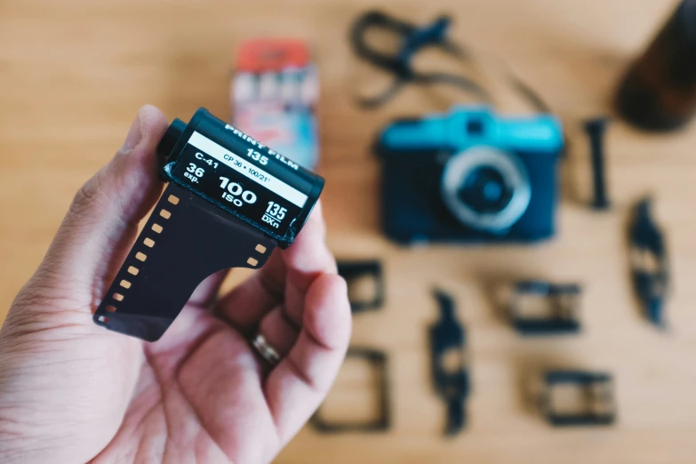 hand holding camera and recording equipment with a wood surface