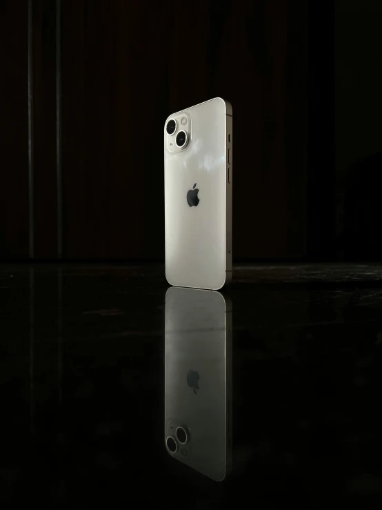 an apple phone is placed in front of a dark background