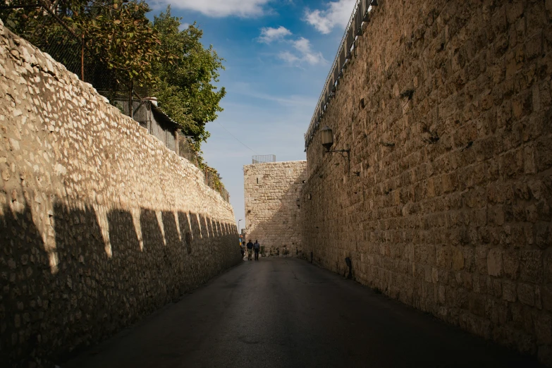 the paved road is lined with brick retaining walls