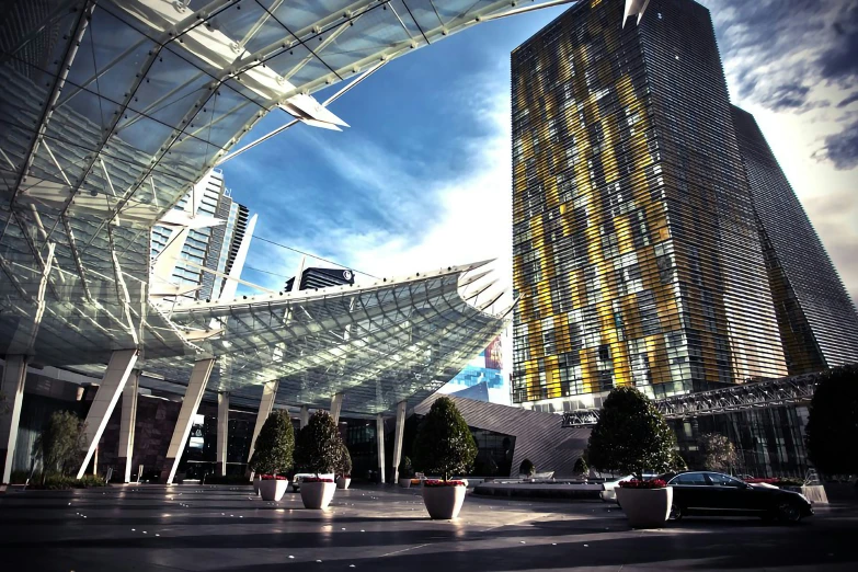 a parking garage with glass roof and cars driving in the foreground