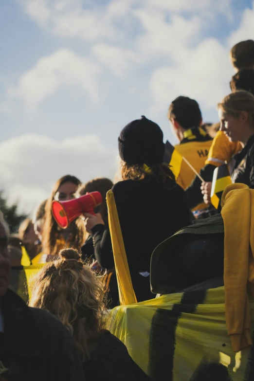 people in yellow and black dress sitting and standing in a group