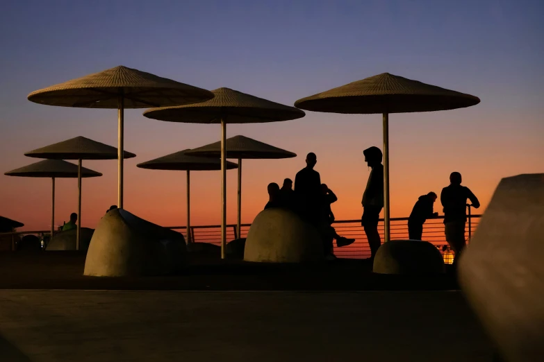 two men standing at the end of a pier, under umbrellas