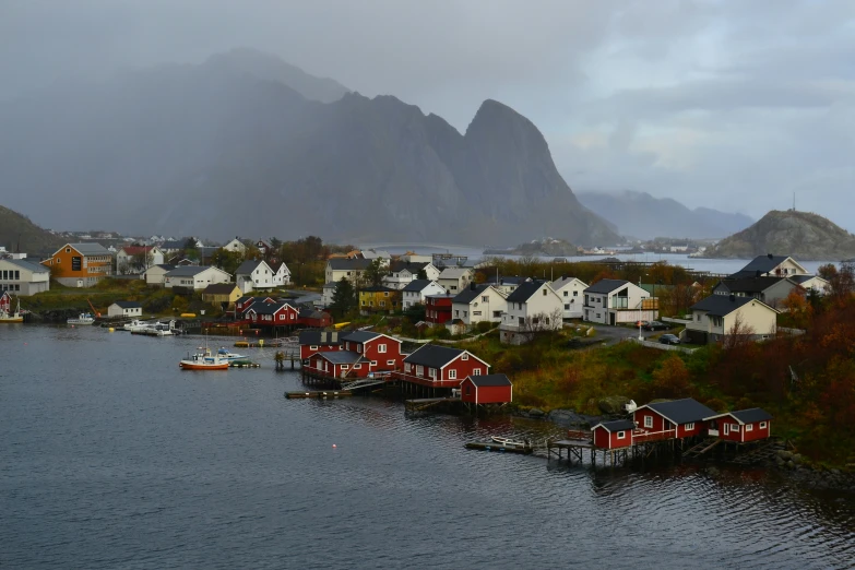 a boat is docked in the water near houses and mountains