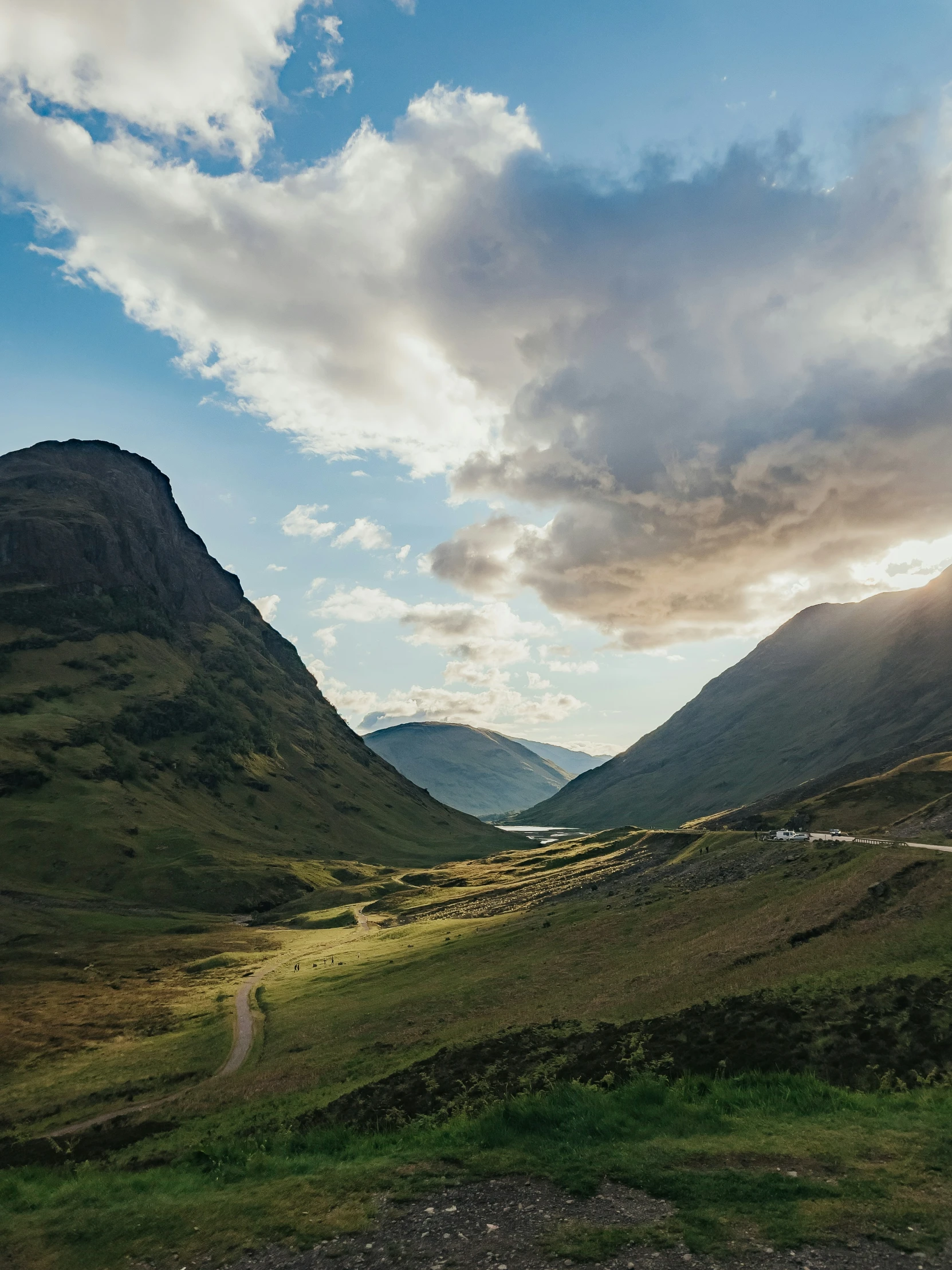 the view of the road and mountains in the evening time