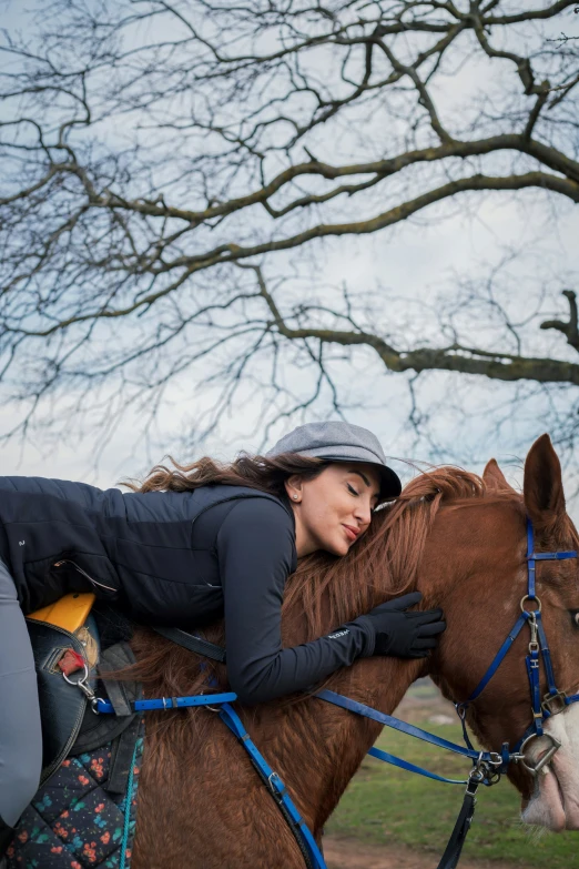 a woman riding on the back of a brown horse