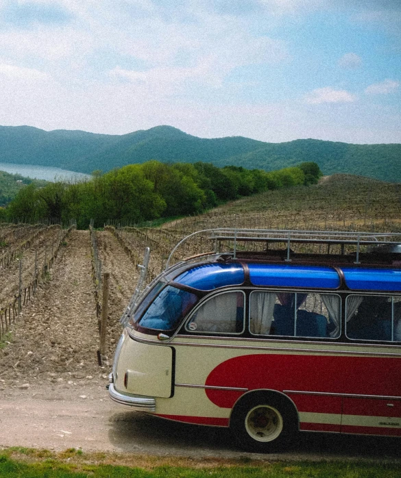 a red white and blue bus parked in a parking lot