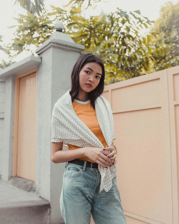 a woman wearing jeans and an orange top