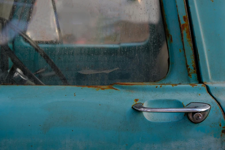 the door handle on an old, blue truck