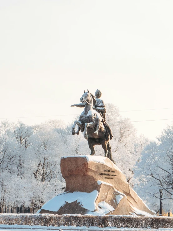 a snow covered statue depicting two people riding horses