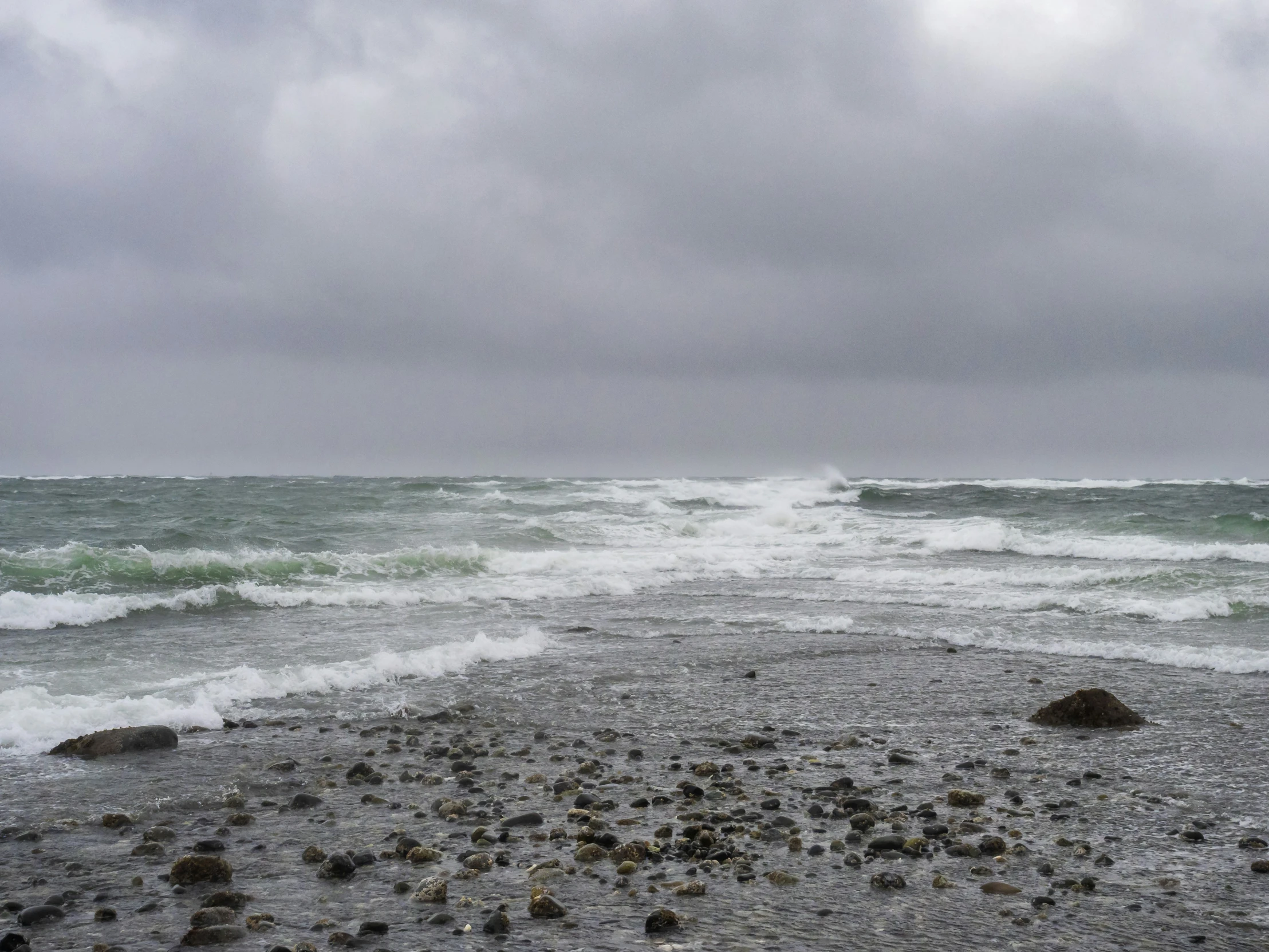 an ocean shore with lots of waves coming in on the shore