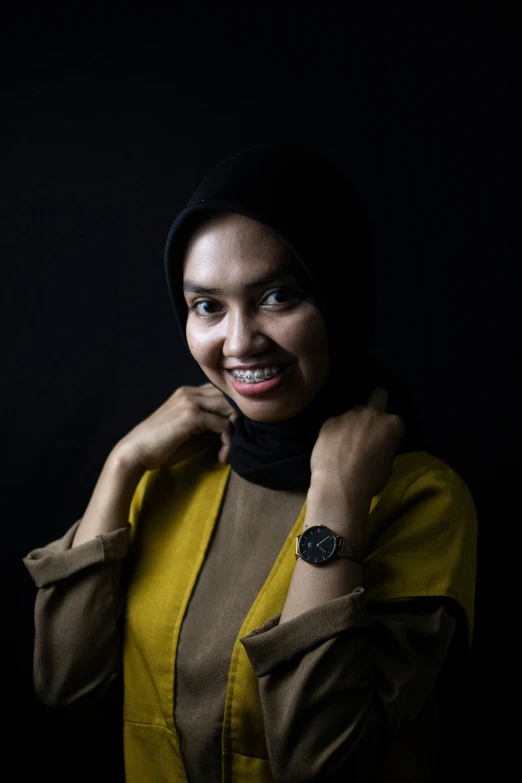 a woman wearing a black and yellow shirt smiling