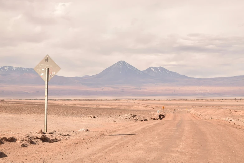an image of desert road with mountains in background