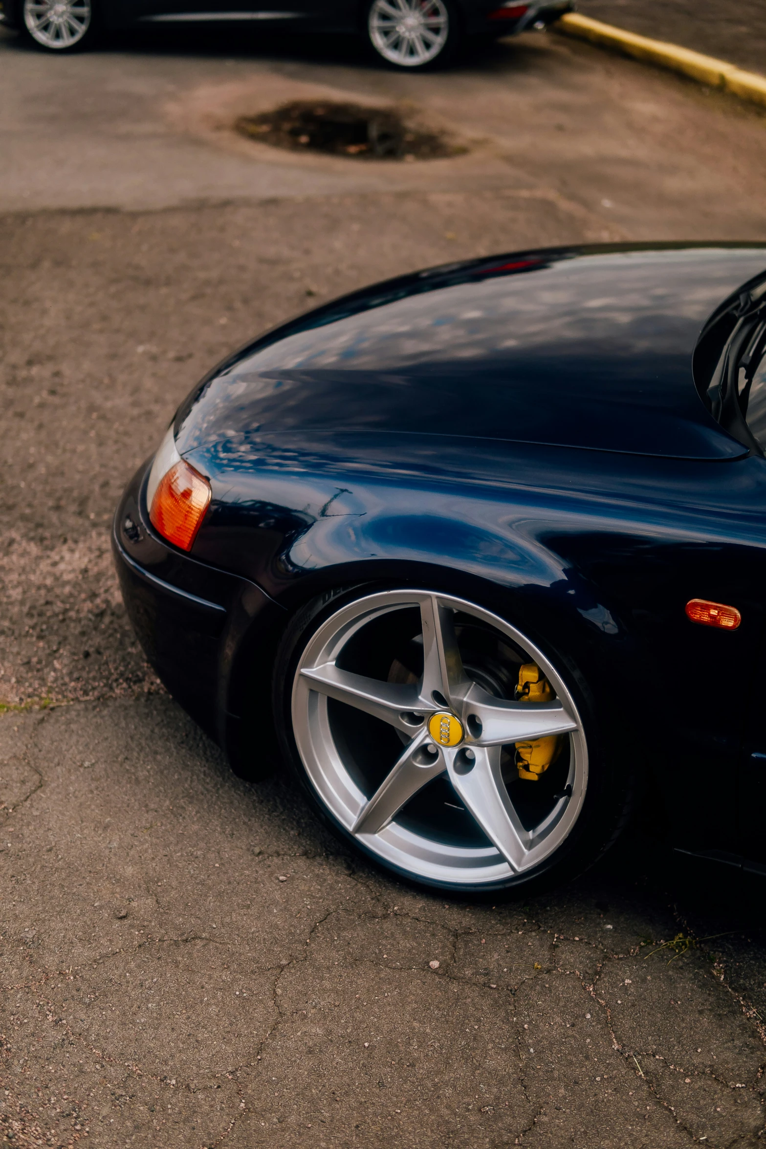 a blue sports car is parked on the side of the street