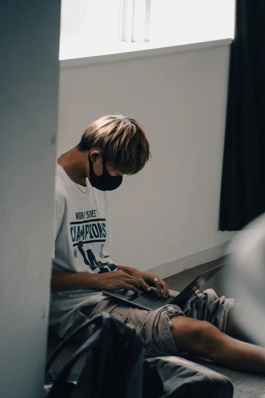 a man sitting on top of a bed next to a wall