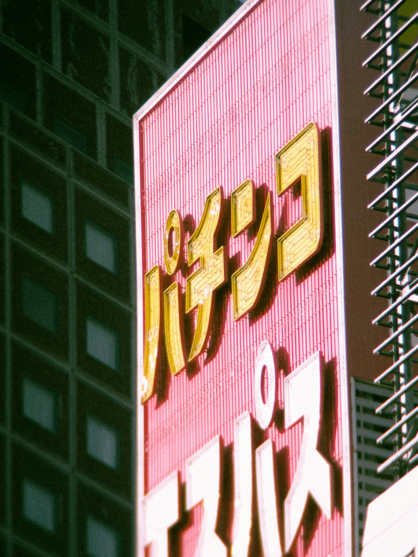 a colorful sign in japanese on top of a skyscr