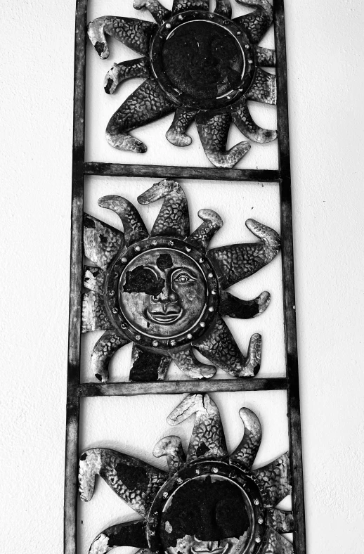 a decorative metal wall hanging with a sun face