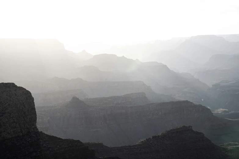 a man is standing on the top of a mountain looking over