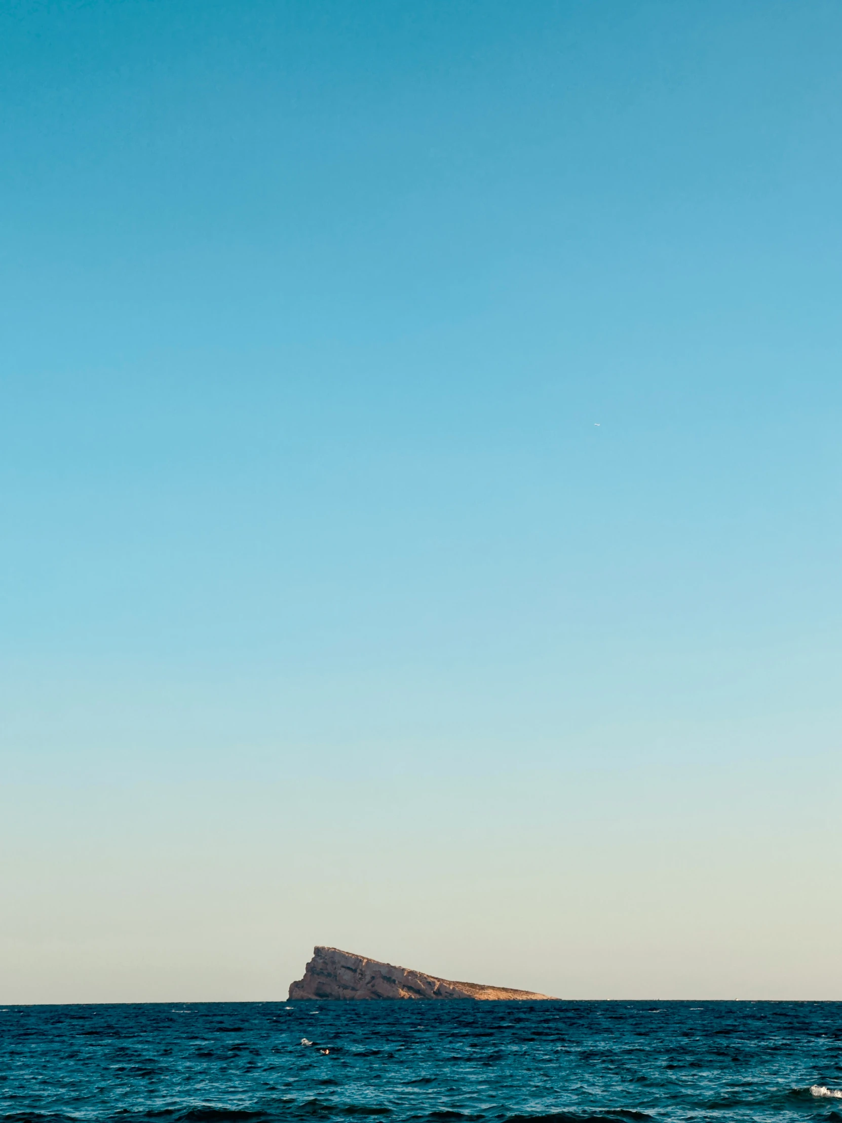 some small island sitting above some blue water