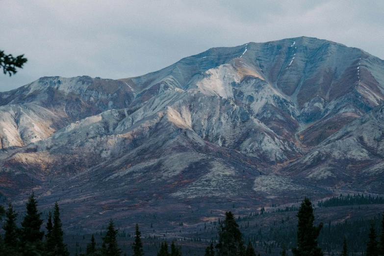 a mountain range is seen under a cloudy sky