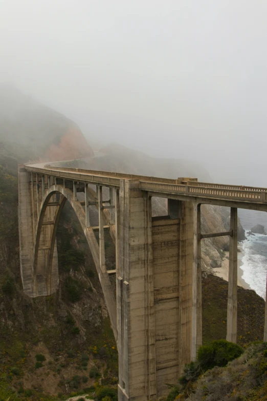 a road leading to the ocean with bridge next to it