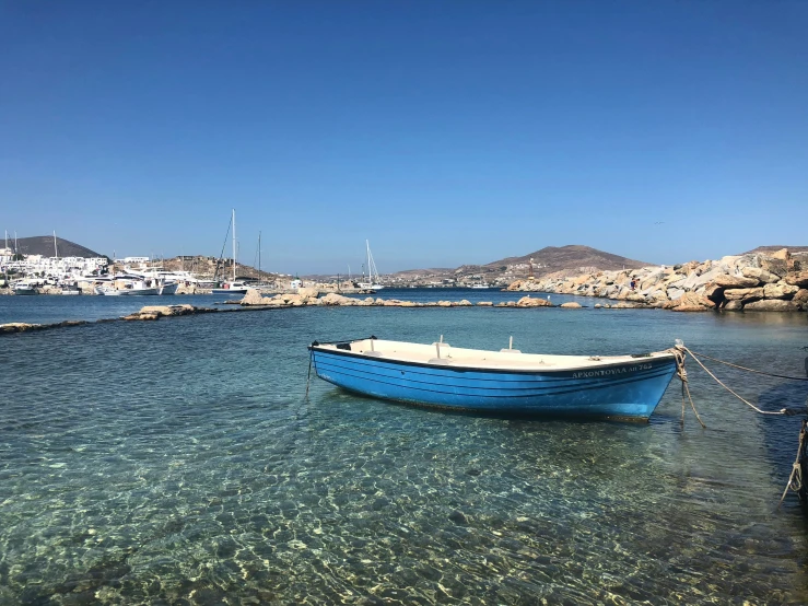 a boat anchored at a sandy shoreline in a bay