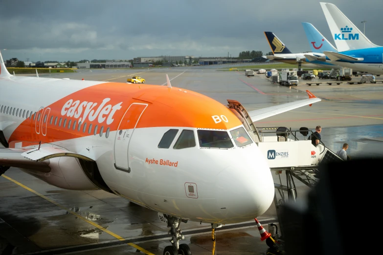 an orange and white plane parked at the runway