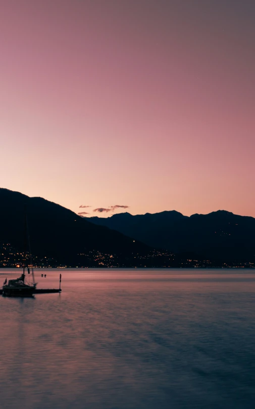 a boat is in the calm water as the sun is setting