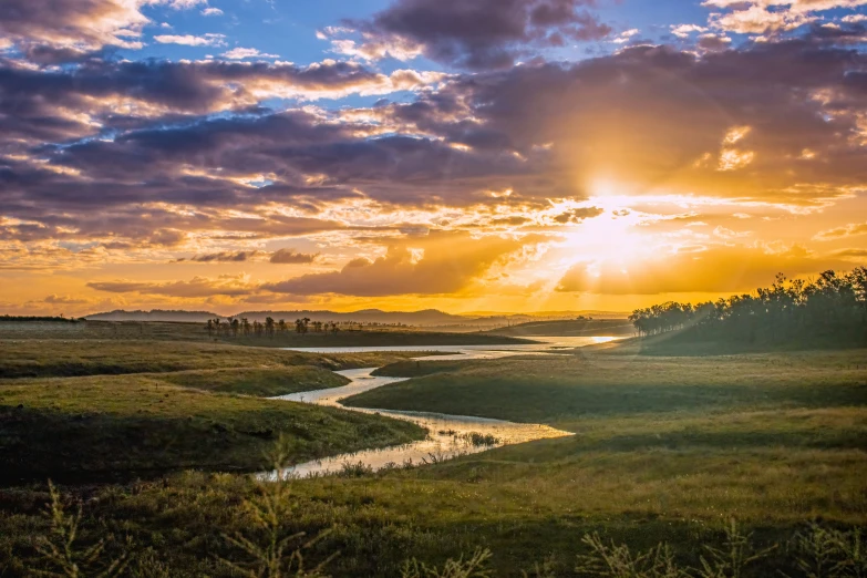 some very pretty sunsets over a river in the countryside