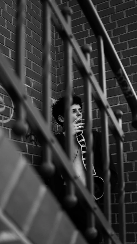 a man looks down at the wall while holding his head