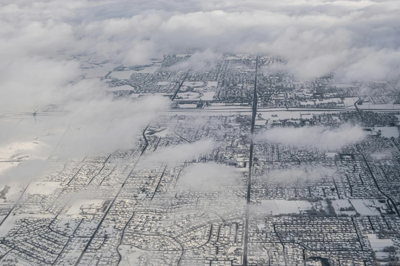 the view from an airplane looking down at the town below the clouds