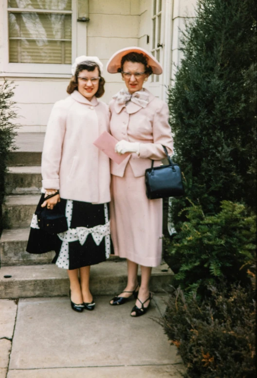 two women are standing outside on some steps