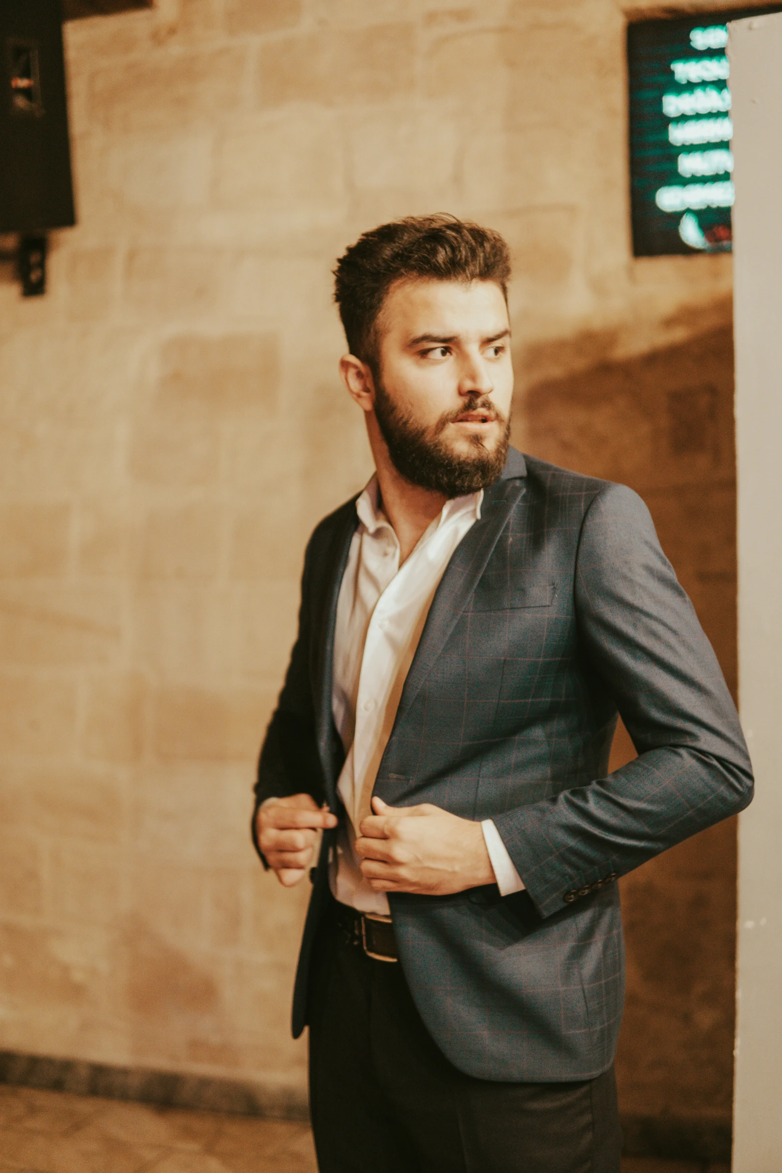 a man standing in front of a wall with a tie on