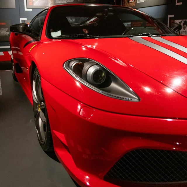 the front of a red sports car parked in a garage