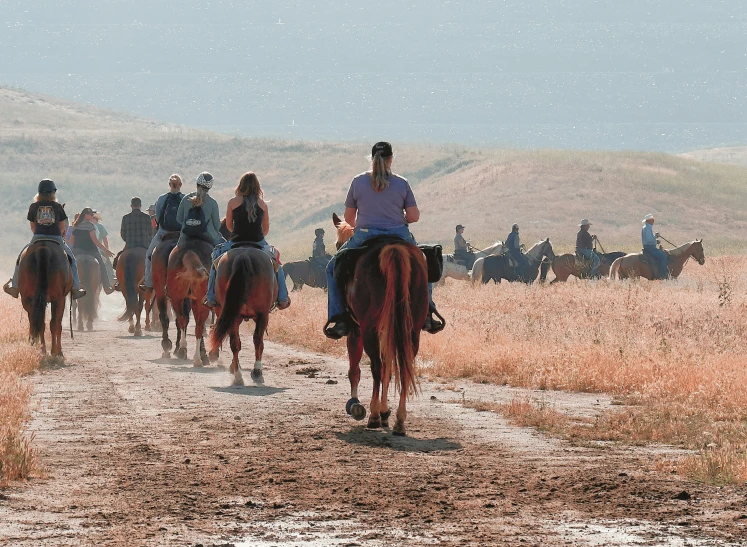 the men are riding their horses around the desert