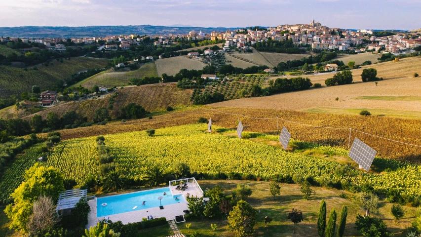 an aerial view of a swimming pool and a countryside area