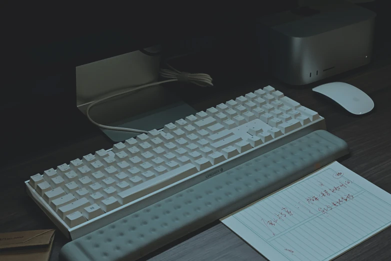 a computer keyboard with a mouse and paper on the desk