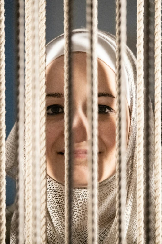 a woman standing in front of a window in a prison cell