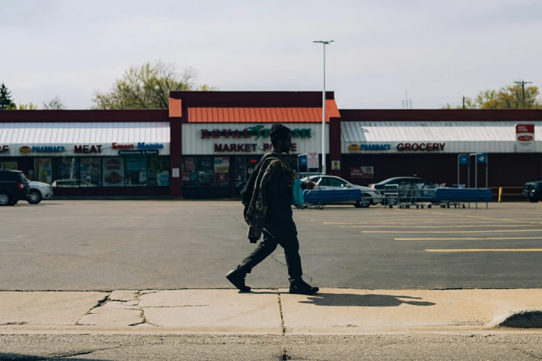 a man walking down the street in front of a store