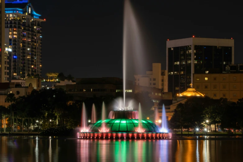 the fountain is lit up on a night